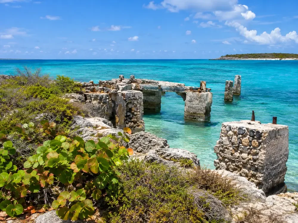 Weathered stone and concrete remains of an old quarry pier on a rocky shore
